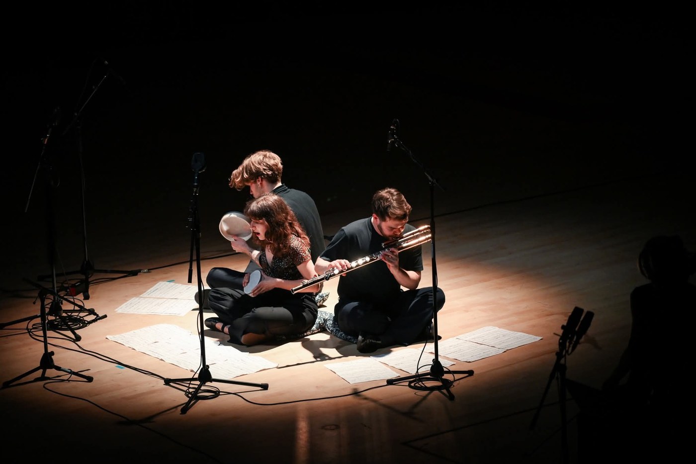 Trio performing with flute, percussion, and voice