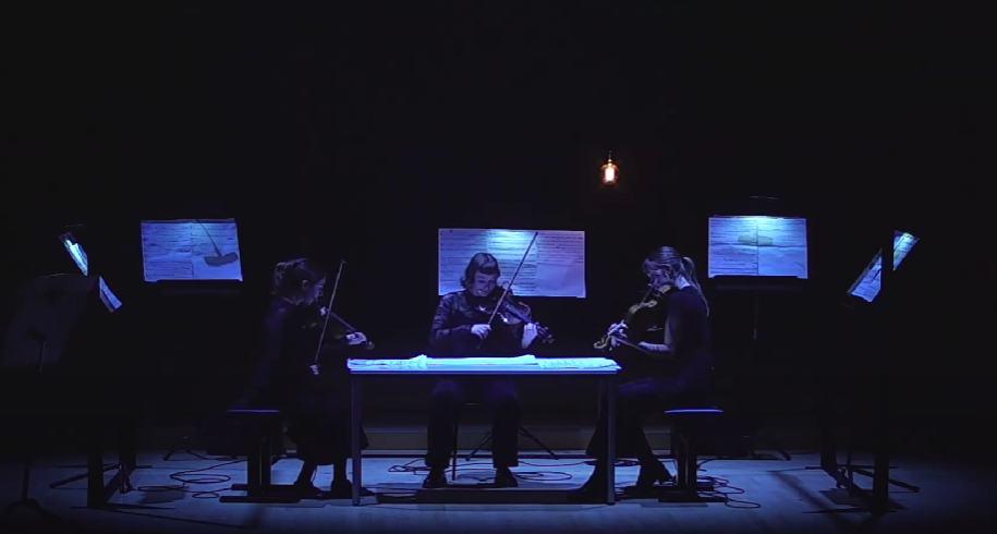 String trio performing at a lit table